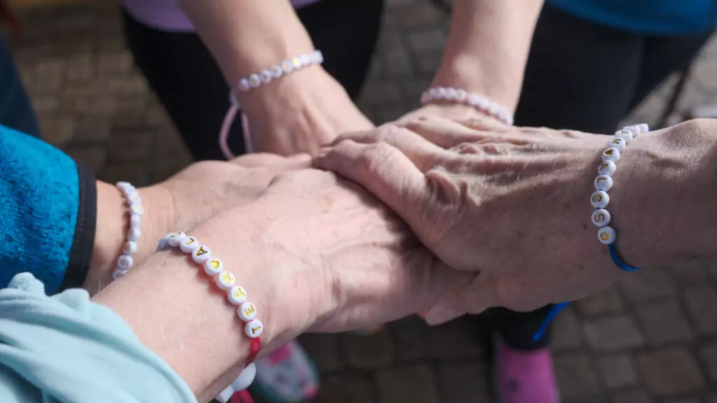 ALGSO members joining hands with Team ALGSO bracelets at Run4Cancer 2025 Differdange.