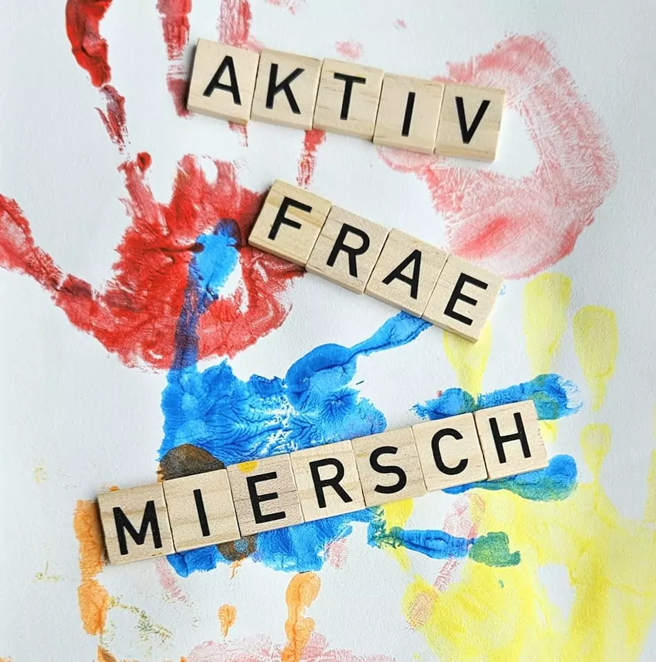 a group of wooden blocks with letters on a white surface with colorful handprints